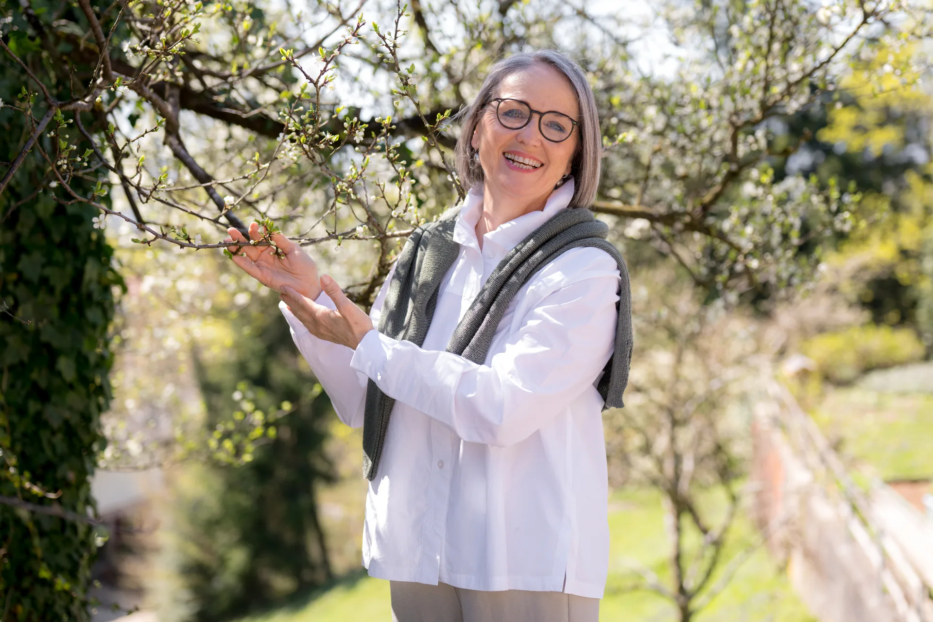 Ute Hefel im Garten bei einem blühenden Baum